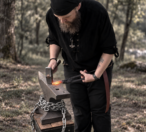 James Anderson forging hot metal at an anvil